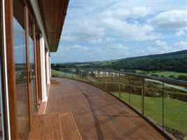 Large curved balcony in Royal Chrome handrail with a beautiful countryside view