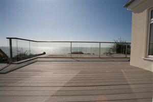 Large balcony with bronze handrail looking out at the stunning coast
