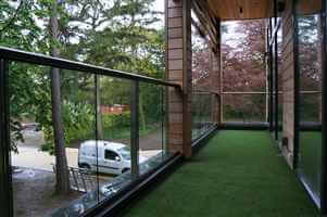 Royal Chrome aerofoil balconywith clear glass surrounded by woodland