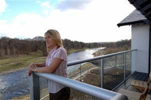 Woman enjoying the view from the balcony with silver handrails