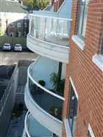 Curved balconies with silver handrails and privacy screens
