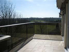 Bronze handrail balustrade with grey tinted glass overlooking beautiful countryside