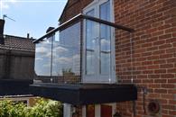 Replacing a rotten timber balcony with a clear glass one supplied by Balconette has given this semi-detached cottage in North Bradley, Wiltshire a contemporary new look to the delight of its owners Alan and Trudy Shellard.