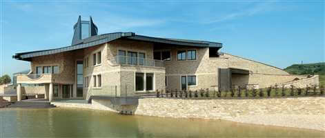 Large beautiful house with Silver balustrades surrounded by a lake