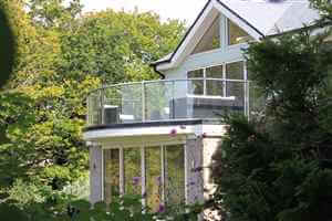 Looking through foliage at beautiful house with Royal Chrome balustrade