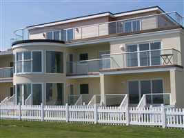 Curved and straight balustrades and Juliet balcony on coastal residency by the coast