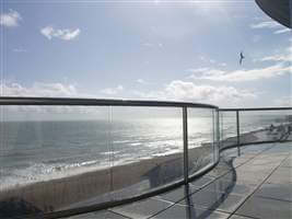 glass balustrade with chrome handrails on the seaside