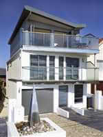 Interestingly designed clear glass balconies with silver handrails and posts