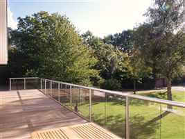 Wide balustrade with silver handrails and posts looking out to beautiful gardens