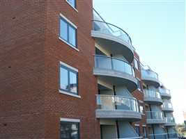 Side view of several curved balconies with silver handrail