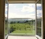 View to the beautiful country side through a Juliet balcony with a white handrail