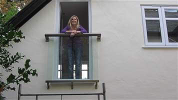 Woman leaning on her small Royal Chrome Juliet balcony