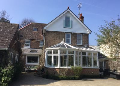 Frameless Juliet Balcony installed on an older style house with a conservatory