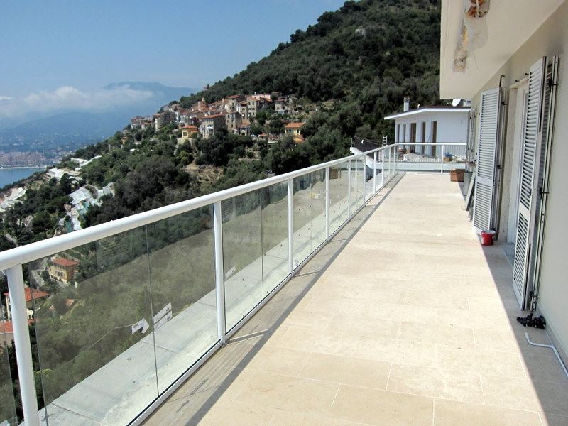 A long White Orbit Glass Balustrade installed on a mountain top property with beautiful views and blue skies
