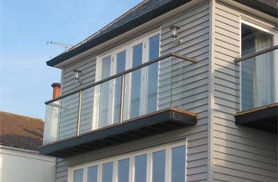 Short clear glass Bronze balcony on the side of a pretty house