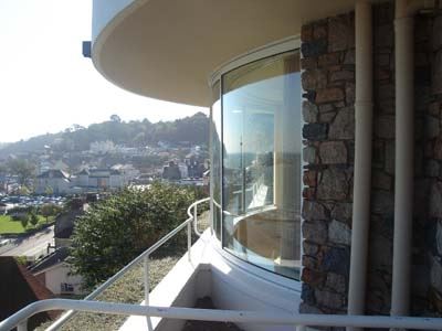 White Curved Glass Doors installed on a hill top brick property