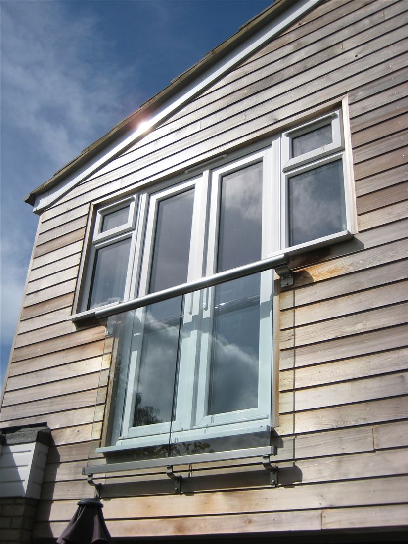 Royal Chrome Orbit Juliet Balcony installed on a house with wooden cladding